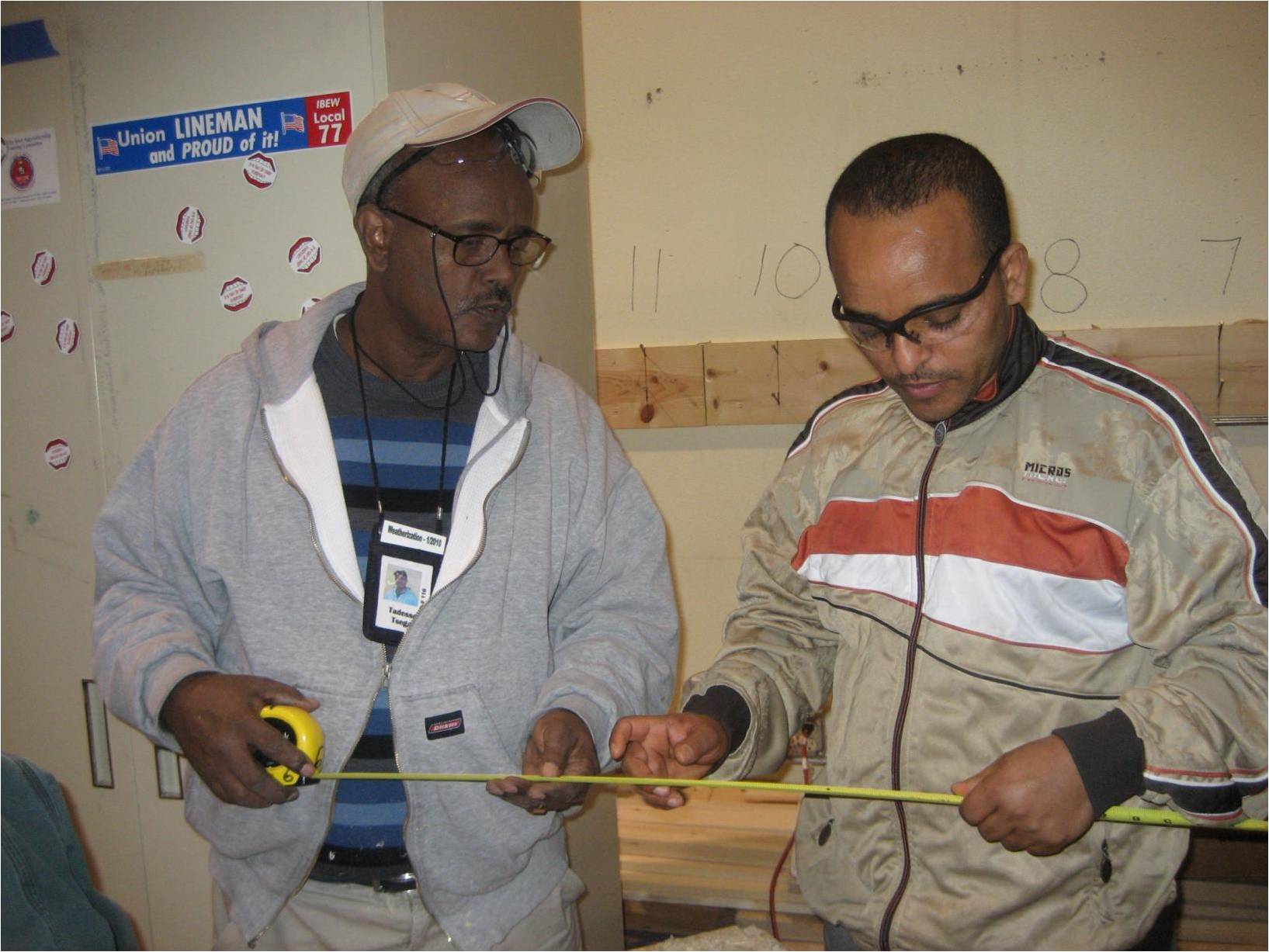 travato_weatherization_two_men_with_measuring_tape_and_union_label